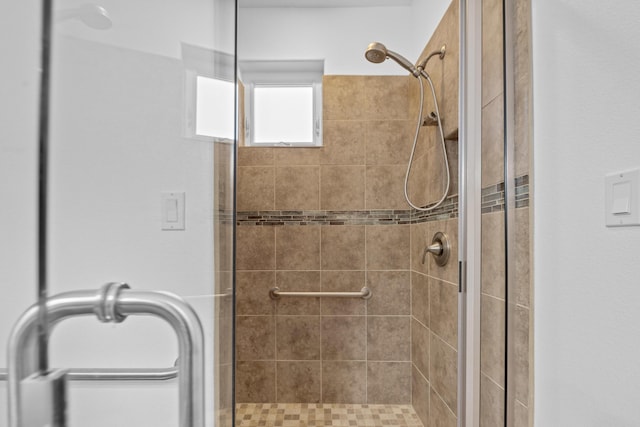 bathroom featuring a shower with shower door