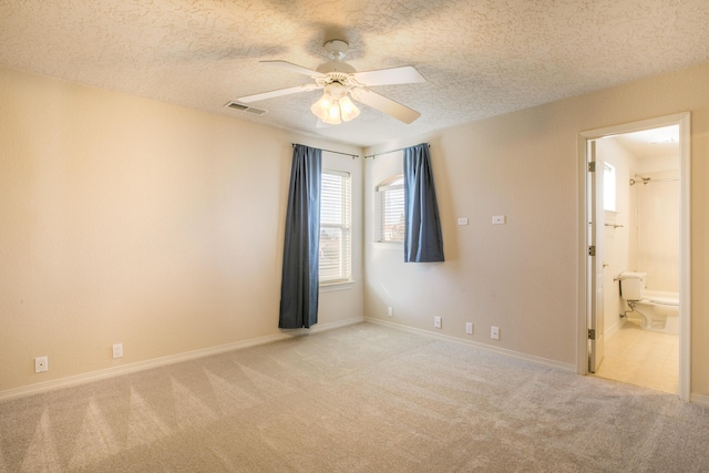 carpeted empty room with ceiling fan and a textured ceiling