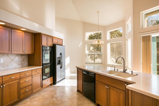 kitchen featuring hanging light fixtures, black appliances, sink, backsplash, and a chandelier