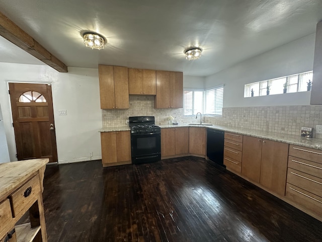 kitchen featuring light stone counters, dark wood-style flooring, backsplash, a sink, and black appliances