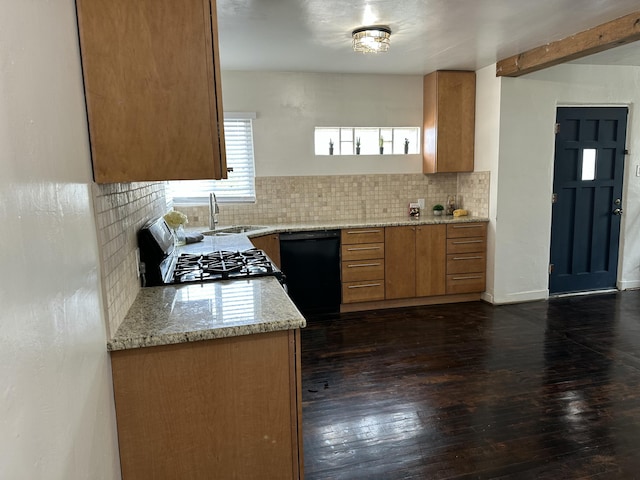 kitchen featuring black dishwasher, tasteful backsplash, a sink, light stone countertops, and range