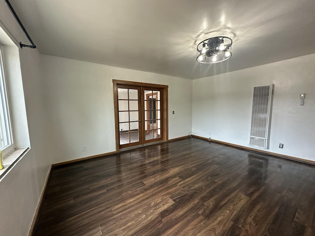 spare room with visible vents, baseboards, dark wood-style flooring, and french doors