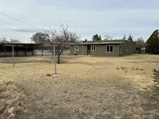 ranch-style house with a front lawn and stucco siding