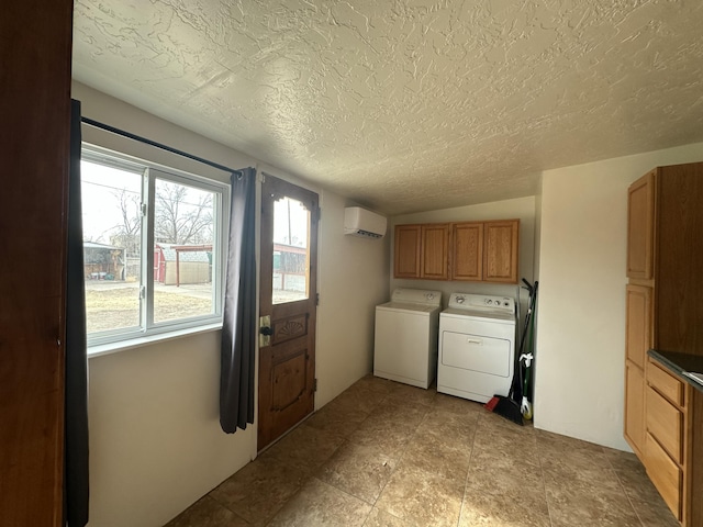 clothes washing area featuring cabinet space, a textured ceiling, separate washer and dryer, and an AC wall unit