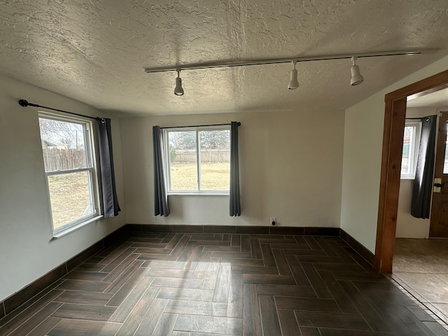 empty room with baseboards and a textured ceiling