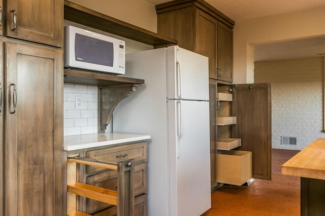 kitchen with backsplash and white appliances