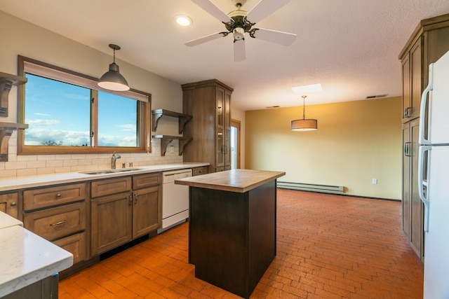 kitchen featuring a center island, hanging light fixtures, baseboard heating, a sink, and white appliances