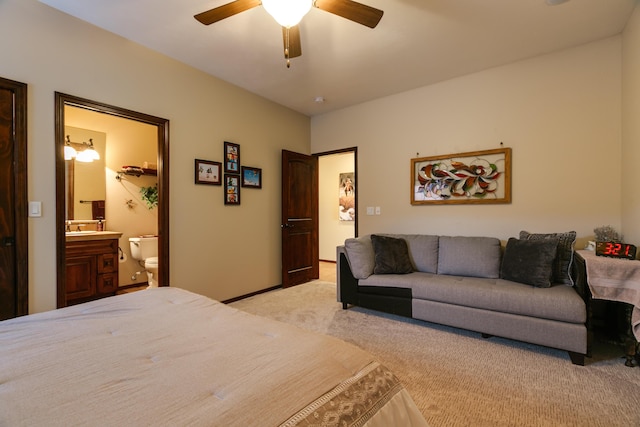 bedroom featuring light carpet, ceiling fan, and ensuite bathroom