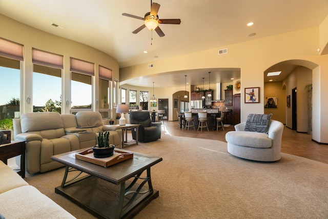 living area with arched walkways, visible vents, and recessed lighting