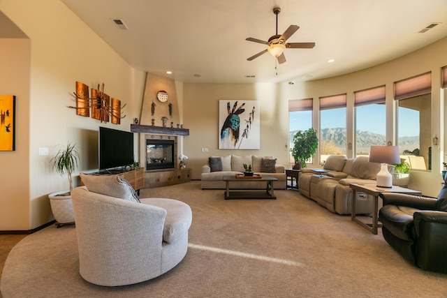 living room featuring visible vents, carpet flooring, a ceiling fan, and a tile fireplace