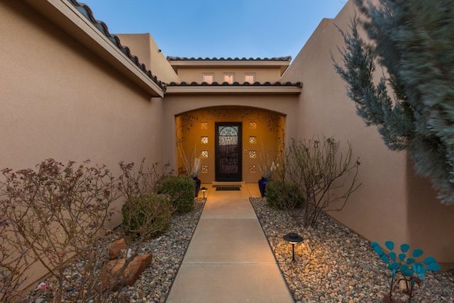 doorway to property featuring stucco siding