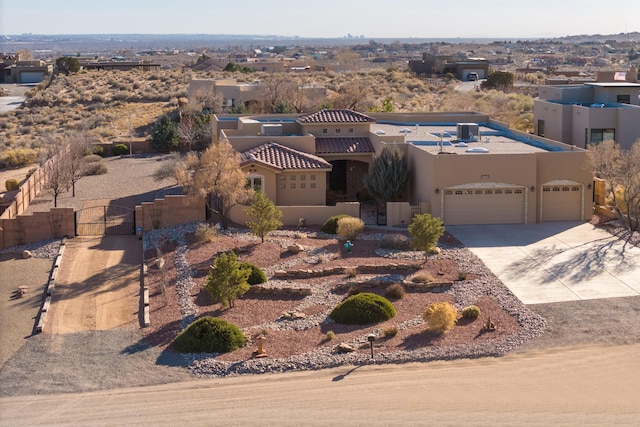 view of front of home featuring a garage, concrete driveway, a gate, fence, and stucco siding