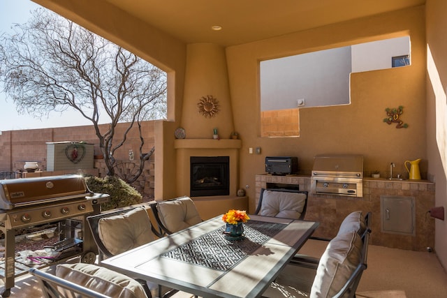 view of patio featuring exterior kitchen, a sink, area for grilling, and an outdoor living space with a fireplace