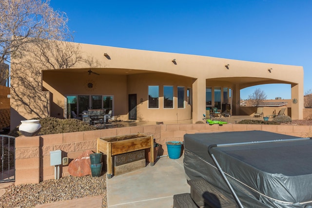 rear view of property featuring ceiling fan, a patio, and stucco siding