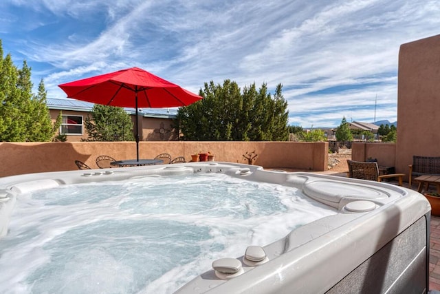 view of swimming pool with a hot tub