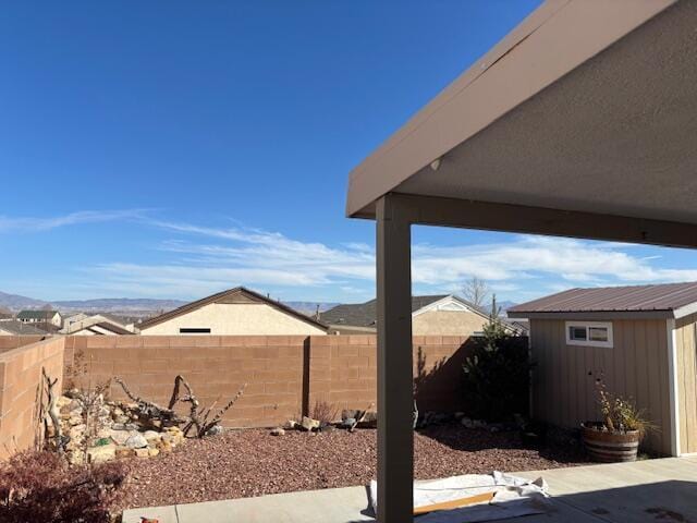 view of yard with a shed, a patio, a fenced backyard, and an outdoor structure