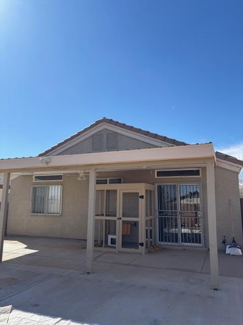 back of property featuring stucco siding