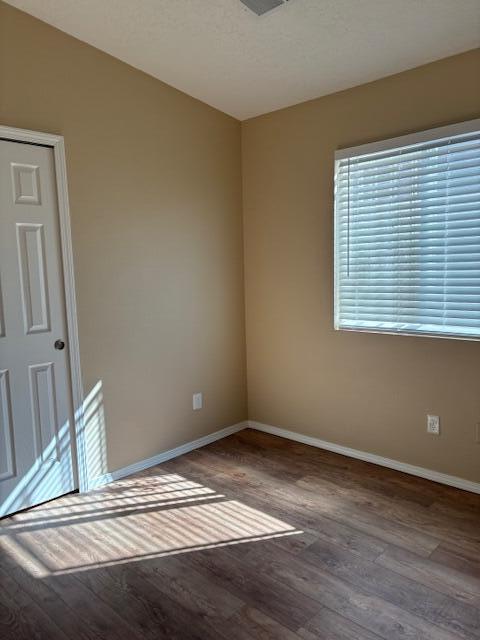 empty room with wood finished floors and baseboards