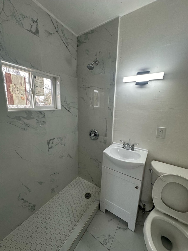 bathroom with marble finish floor, toilet, a shower stall, and vanity