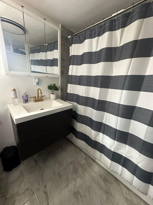 bathroom featuring marble finish floor, curtained shower, and vanity