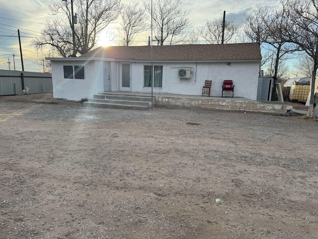 ranch-style house featuring fence and stucco siding