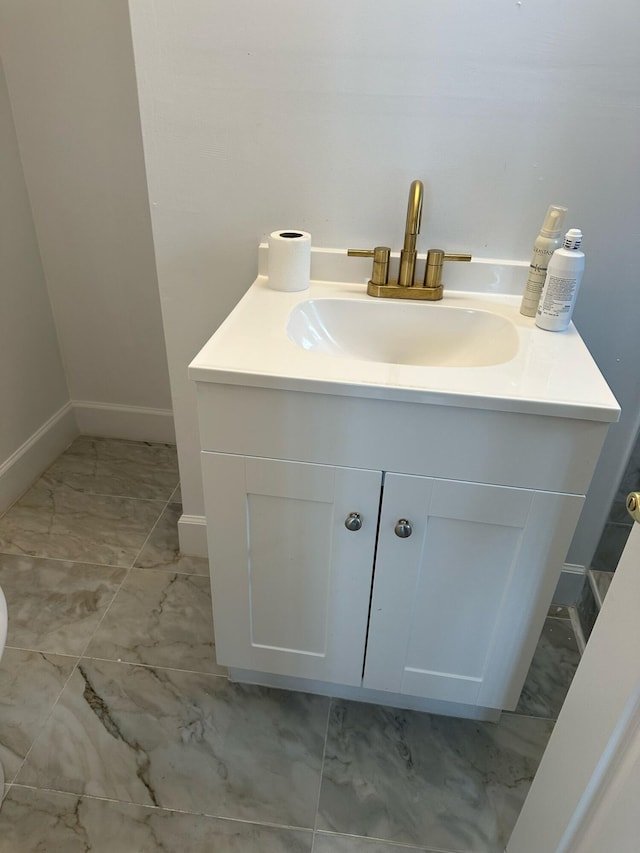 bathroom featuring marble finish floor, baseboards, and vanity