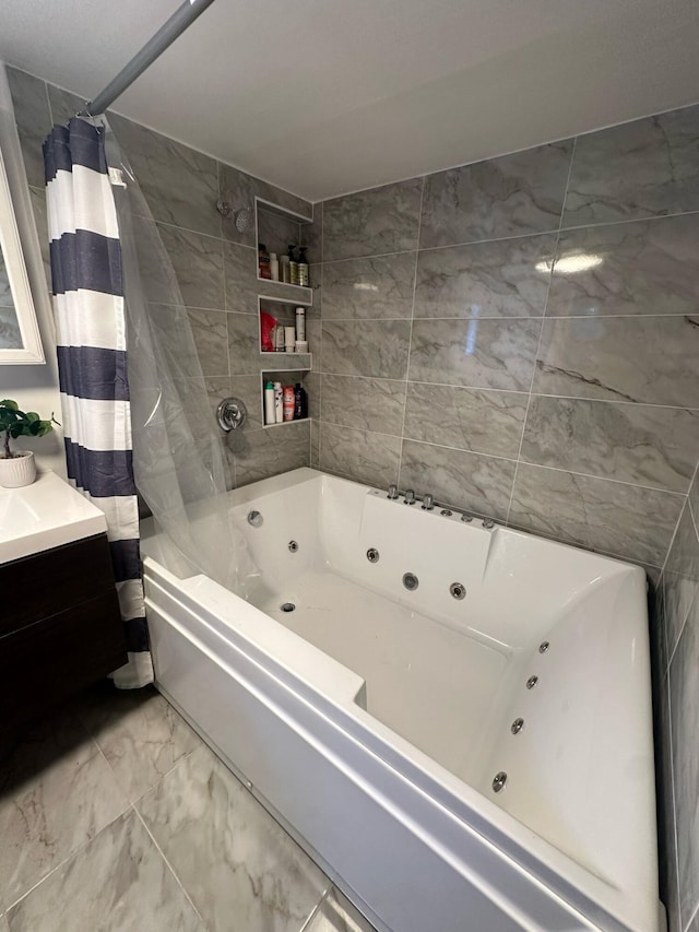 bathroom featuring a combined bath / shower with jetted tub, marble finish floor, and vanity