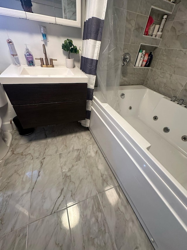 bathroom featuring toilet, marble finish floor, a combined bath / shower with jetted tub, and vanity