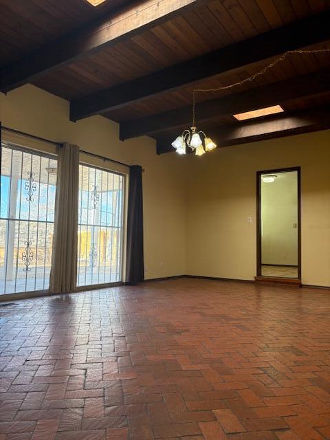 unfurnished room featuring beamed ceiling, a chandelier, and wooden ceiling