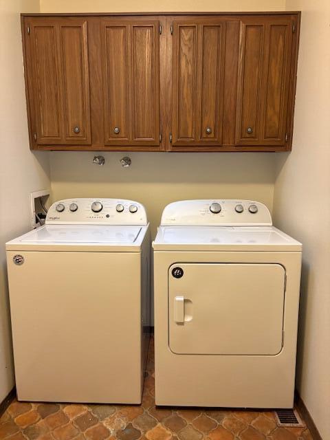 washroom with cabinets and washer and dryer