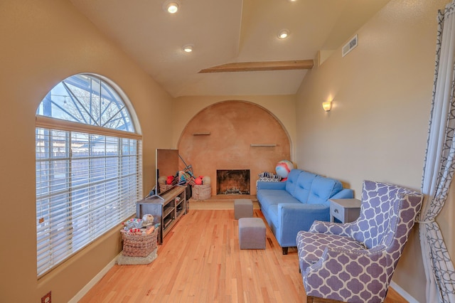 living room with light wood-type flooring and vaulted ceiling