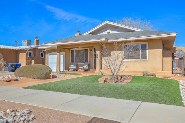 view of front of house with central AC, a front yard, and a garage