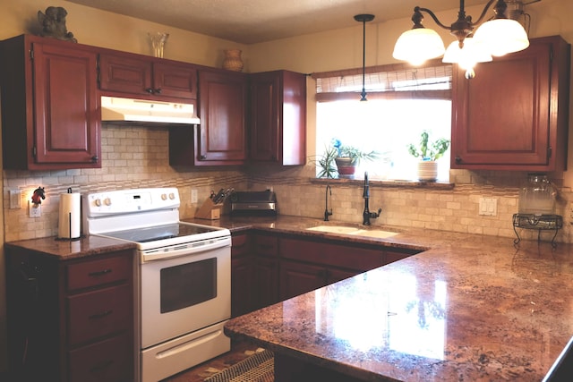 kitchen featuring electric stove, backsplash, under cabinet range hood, pendant lighting, and a sink