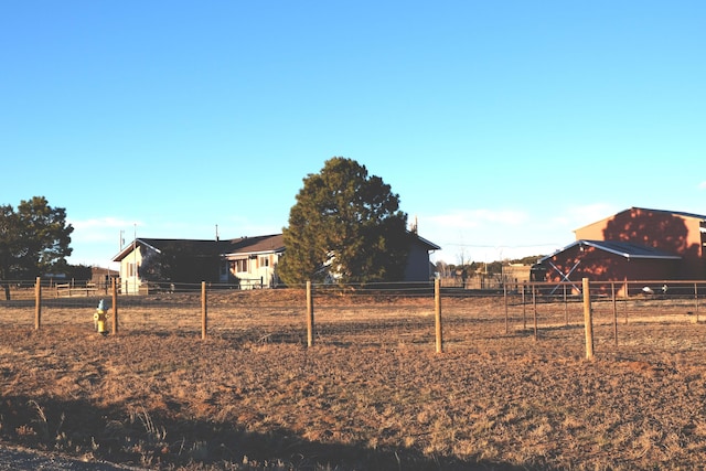 view of yard with a rural view and fence