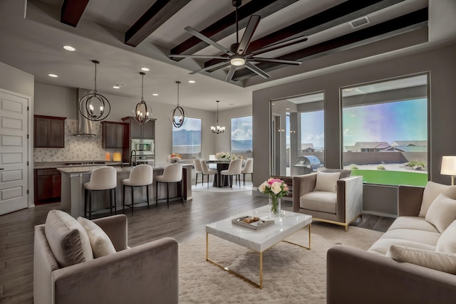 living room with beam ceiling, recessed lighting, visible vents, light wood-style floors, and ceiling fan with notable chandelier