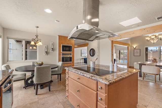 kitchen featuring black electric stovetop, island range hood, a chandelier, built in microwave, and oven