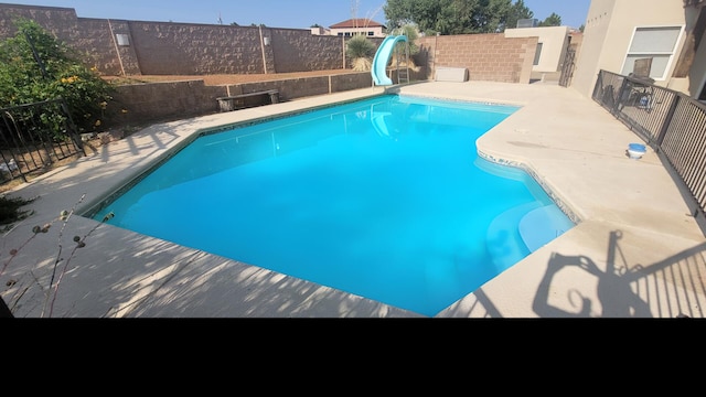 view of pool featuring a fenced in pool, a water slide, and a fenced backyard