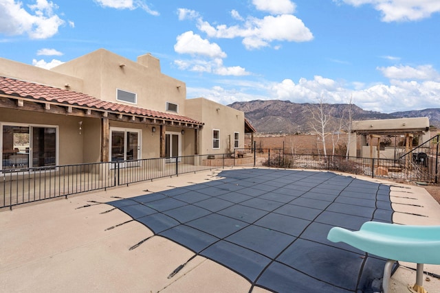 view of swimming pool featuring fence, a mountain view, a fenced in pool, and a patio