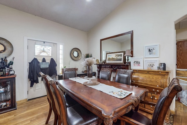 dining area featuring vaulted ceiling and light wood-style floors