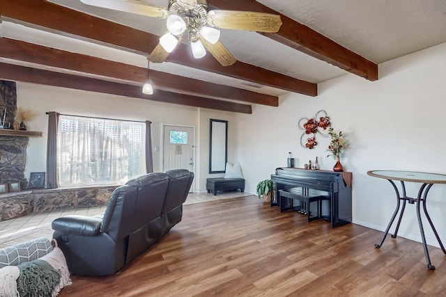 living room with ceiling fan, beam ceiling, visible vents, and wood finished floors