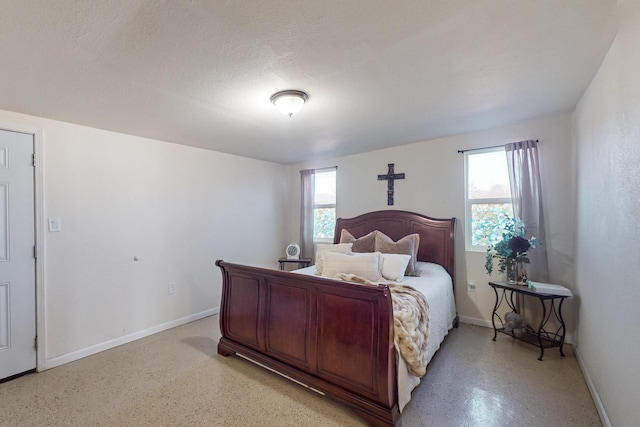 bedroom featuring a textured ceiling and baseboards