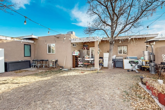 back of house with a patio and stucco siding