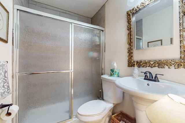 full bath featuring a sink, a shower stall, and toilet