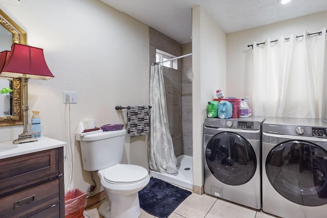 bathroom featuring toilet, a shower stall, separate washer and dryer, and tile patterned floors