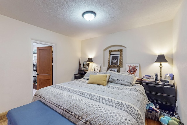 bedroom featuring a textured ceiling and wood finished floors