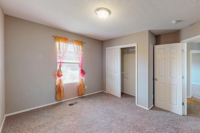 unfurnished bedroom with a closet, light carpet, visible vents, and baseboards