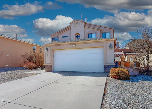 view of front facade with a garage, stone siding, driveway, and stucco siding