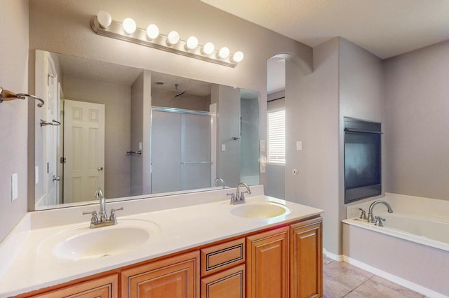 full bathroom featuring double vanity, a stall shower, a sink, and a bath