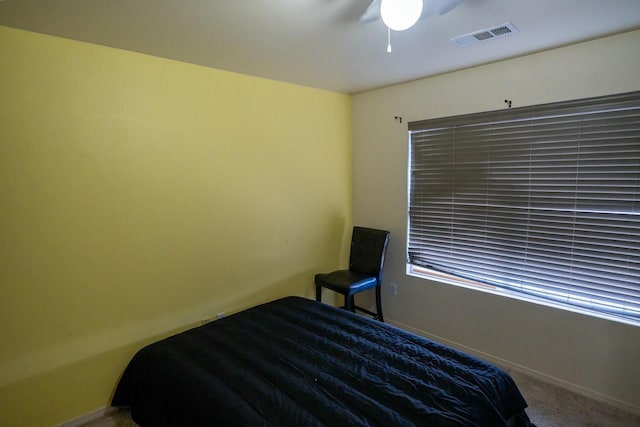 carpeted bedroom featuring ceiling fan, visible vents, and baseboards