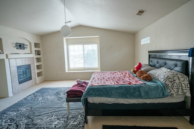 bedroom featuring lofted ceiling, carpet floors, a tile fireplace, and visible vents